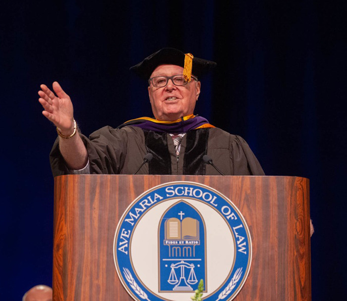 Bill Donohue in academic regalia speaking at a podium with Ave Maria School of Law emblem.