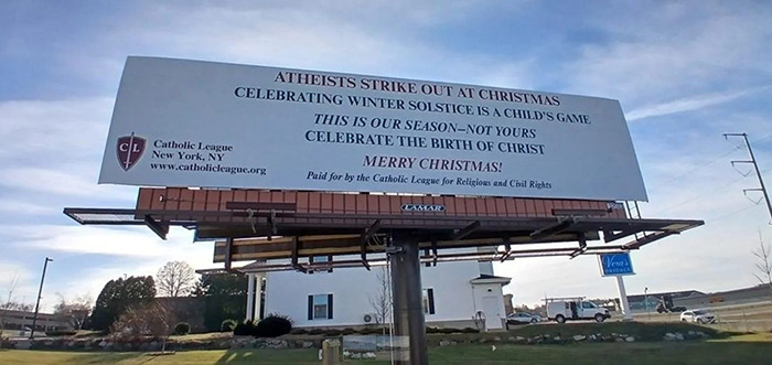 Billboard showing holiday message from Christian group, highlighting Christmas celebration over atheist views.