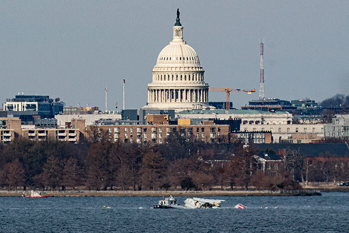 Plane crash site in DC with visible debris in water near the Capitol, highlighting theory of fewer ground lights visible.