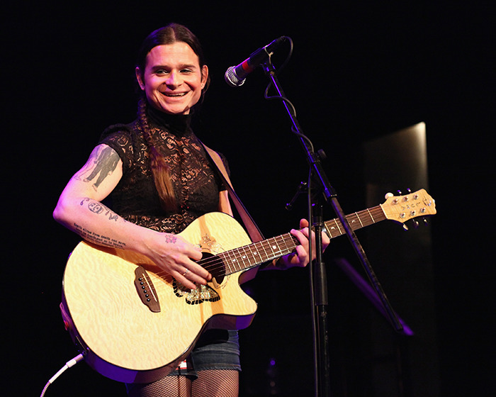 Rock singer performing on stage with a guitar.