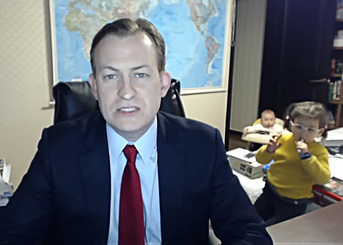 Man in suit being interrupted by kids during BBC interview.