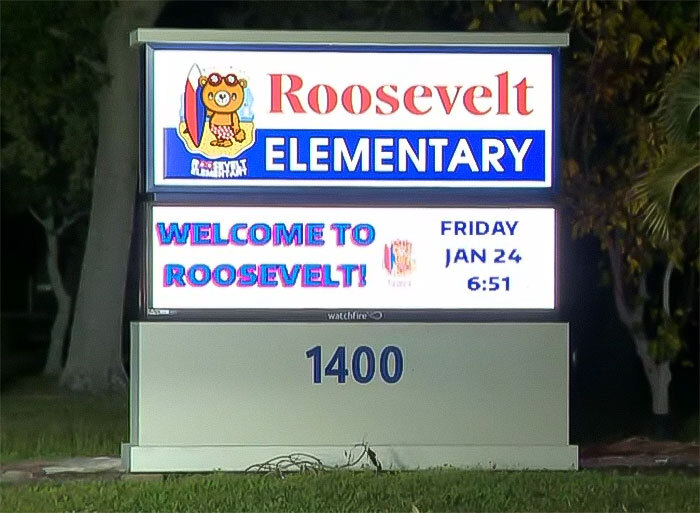 Sign for Roosevelt Elementary, illuminated at night, displaying "Welcome to Roosevelt!