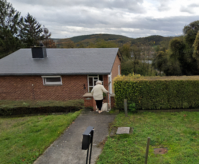 Paulette Landrieux walking towards a brick house, seen from the back, on a cloudy day&mdash;a scene related to mystery of her vanishing.