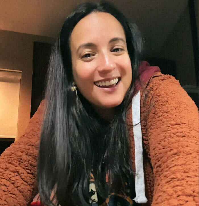 Smiling woman in a brown jacket, related to shady adoption story.