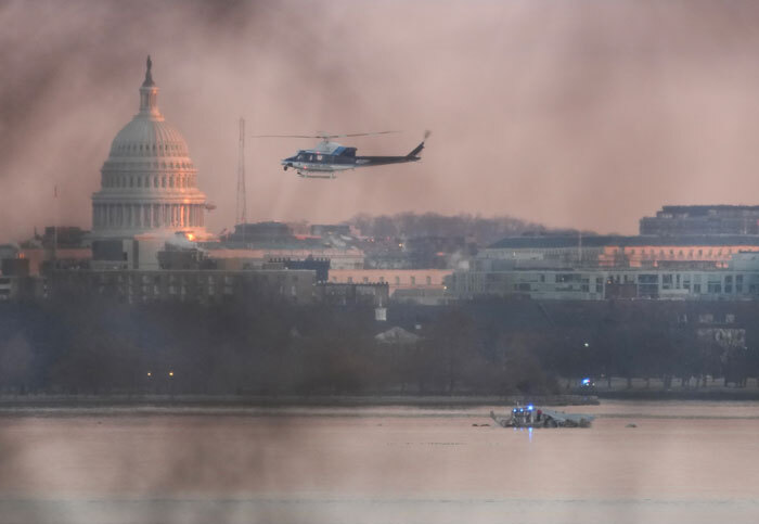 A Black Hawk helicopter flying over DC skyline near the Capitol, with hazy sky, related to a secret drill before a plane crash.