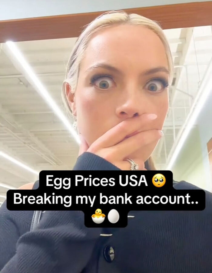 Woman surprised in grocery store with text commenting on high egg prices in the USA.