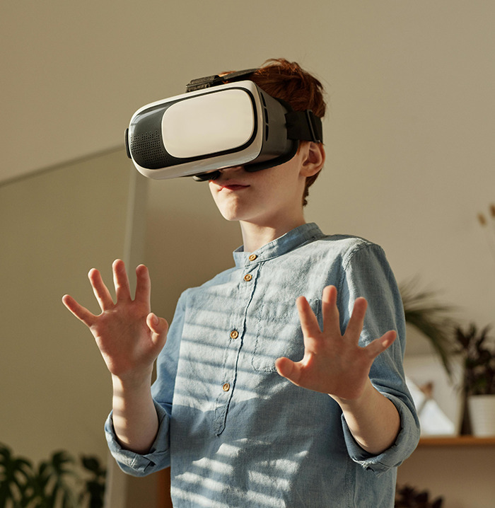 Young boy wearing VR headset, exploring virtual reality in a modern setting.