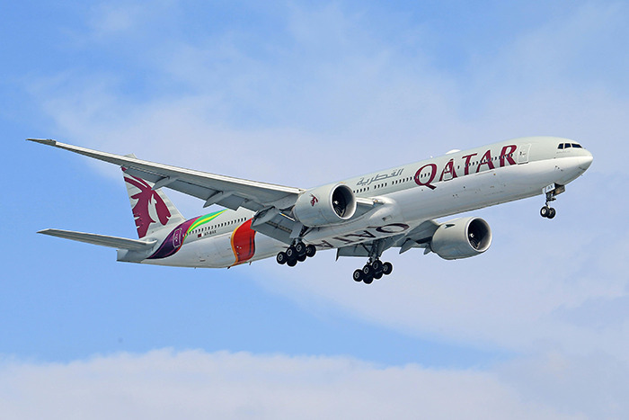 Qatar Airways plane flying in the sky.