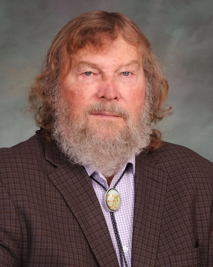 Sen. Tim French in a plaid suit with a bolo tie.