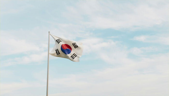 South Korean flag against a cloudy sky, symbolizing political events.