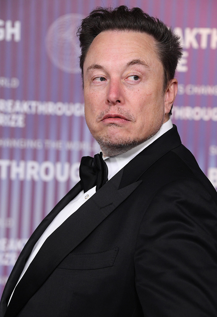 Man in formal wear at event, related to Tesla controversy.