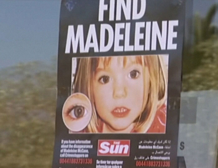 Poster with Madeleine McCann's photo and contact details for missing person information.
