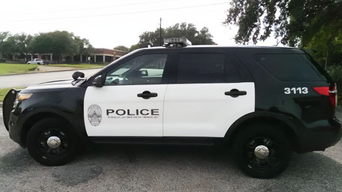 Police vehicle parked on a street related to the arrest of a mortuary worker for alleged misconduct.