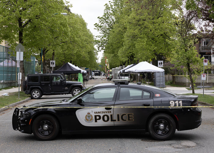 Vancouver police car at festival site following attack suspect's arrest.