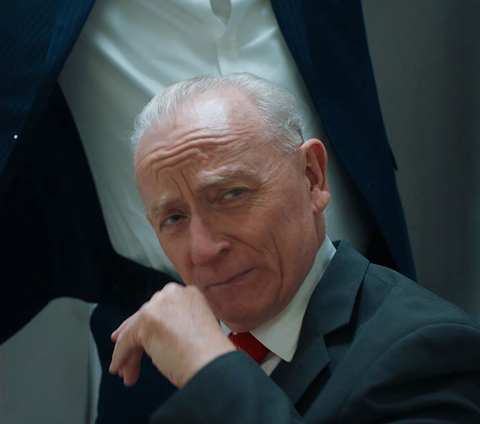 Elderly man in a suit, expressing skepticism; theme related to MAGA and Republican critique.