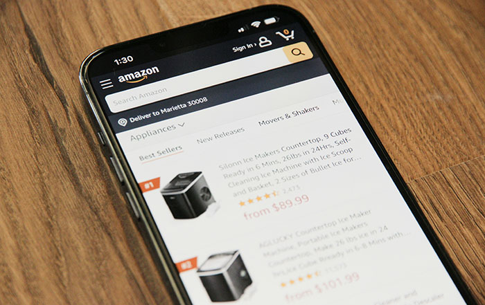 Amazon app open on a smartphone displaying appliance listings amid Amazon delivery drop and UPS job cuts news.