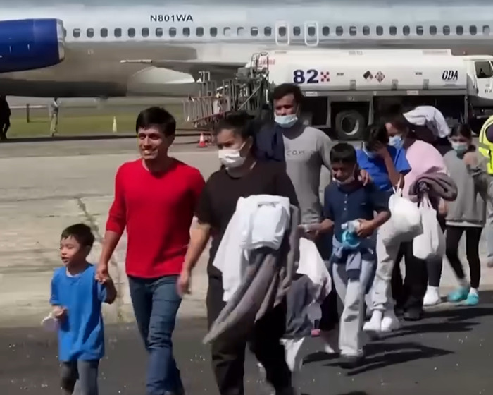 U.S. citizen children, including a young boy, walking near an airplane during deportation without warning at an airport.