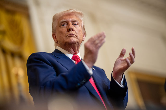 Donald Trump clapping during an event, representing the news about Trump firing Kamala Harris&rsquo; husband Doug Emhoff.