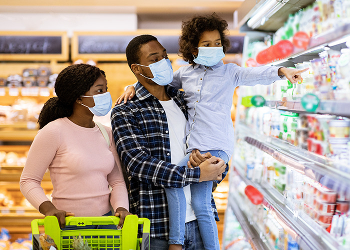 Family wearing masks shopping in grocery store as health experts urge immediate preparedness for bird flu spread across states