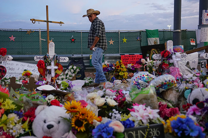 Memorial site in Texas with flowers and crosses after mass shooting targeting Hispanic people.