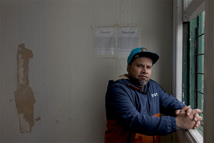 Man in a blue jacket and cap looking out a window, related to ICE agents' mistaken identity issue.