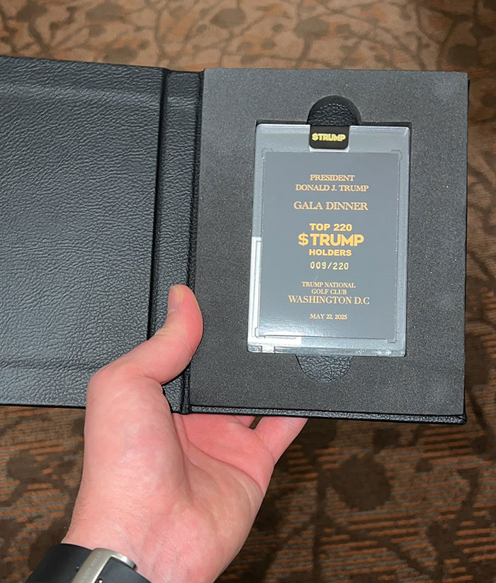 Hand holding a gala dinner pass for top crypto Trump token holders at a Washington D.C. event on May 22, 2025.