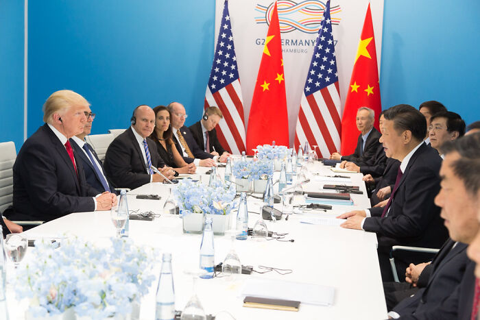 Leaders from the US and China in a high-level meeting, highlighting global trade tensions and China's rising influence.