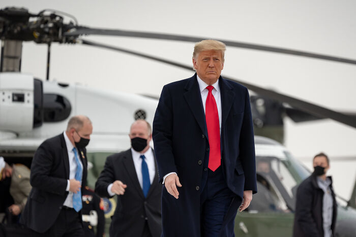 Former President Trump walking near a helicopter, representing tariffs and global trade challenges with China.