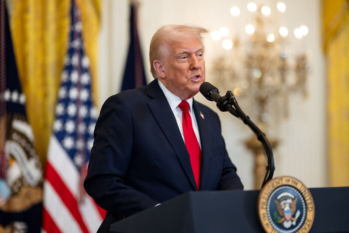 Former President Trump speaking at a podium during a Harvard witch hunt targeting international students investigation.