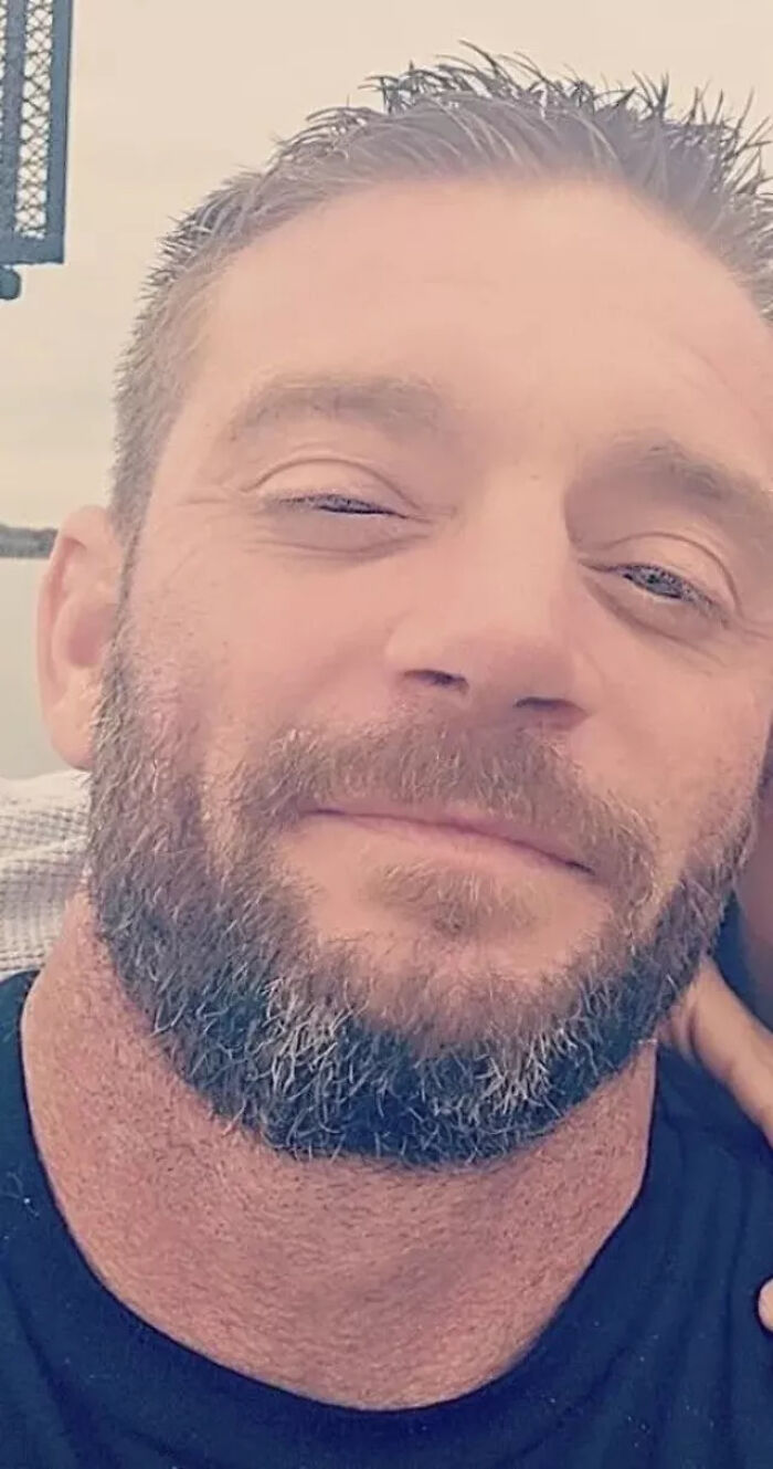 Close-up of a bearded man allegedly involved in a shooting case, facing new charges after his son&rsquo;s tragic death.