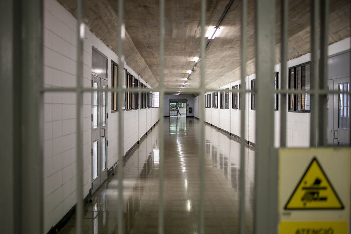 Prison corridor viewed through barred gate symbolizing harsh crackdown on child exploiters and offenders.
