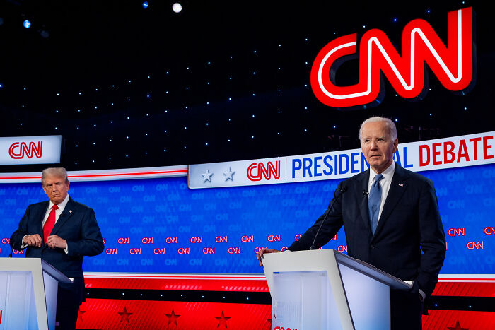 Joe Biden at a CNN presidential debate podium amid cancer diagnosis and conspiracy theories allegations by Republicans.