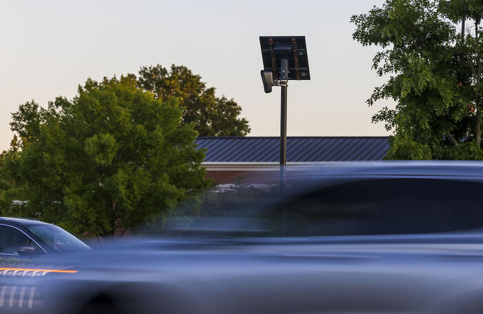 Surveillance camera on a pole in Texas capturing moving cars, illustrating police dystopian tracking methods.