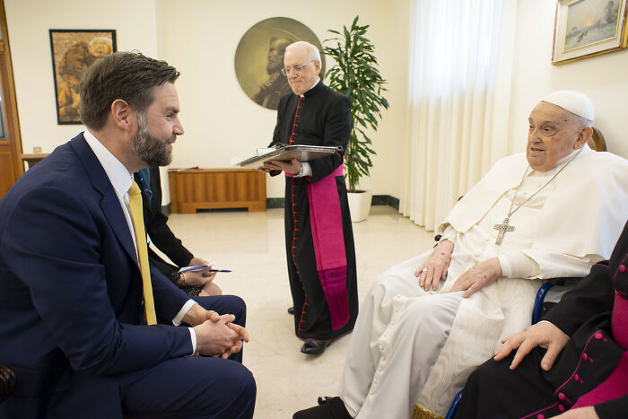 Man in a suit meeting Pope Leo XIV in a formal room, highlighting clues to Pope Leo XIV&rsquo;s agenda and MAGA controversy.