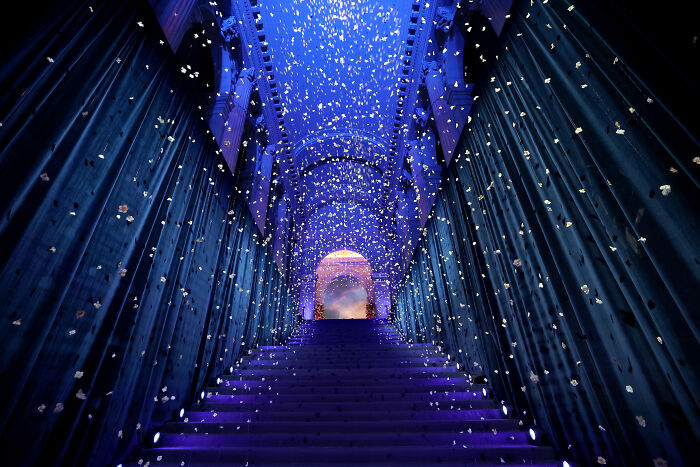 Staircase decorated with blue lighting and falling confetti at an exclusive $75,000-a-ticket Met Gala event.