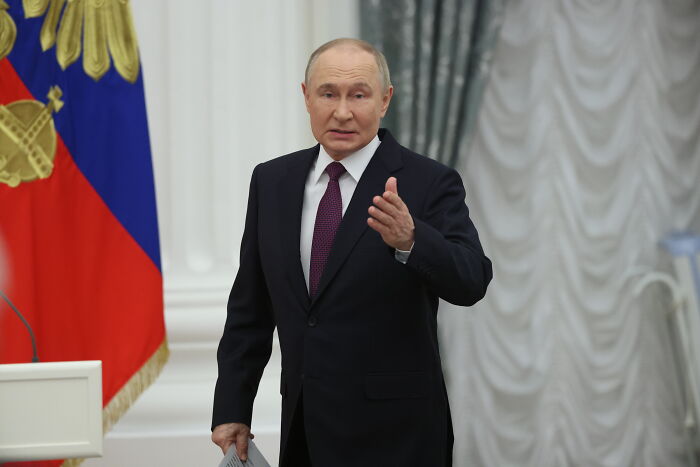 Vladimir Putin in a dark suit gesturing during a speech amid Russia Ukraine conflict after largest Russian attack.