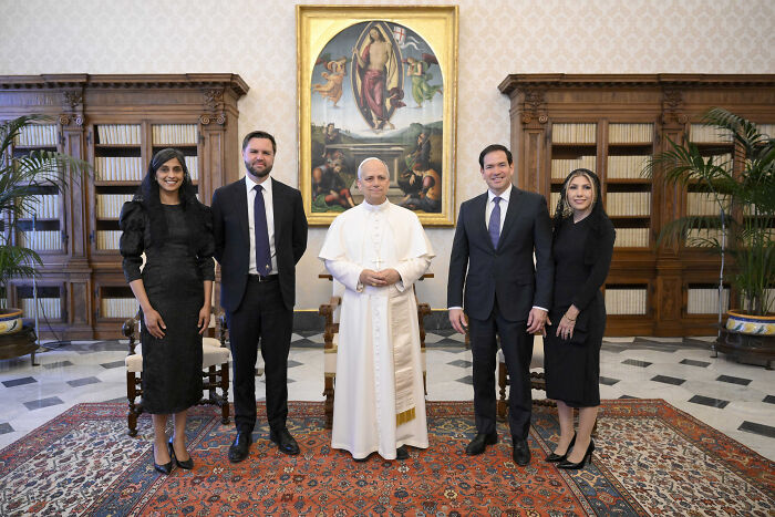 Pope Leo with guests in formal attire in a grand room with bookshelves, featuring JD Vance at inaugural Mass in Rome.
