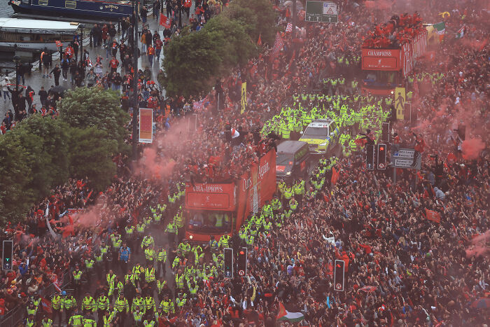Liverpool FC parade with large crowds and heavy police presence amid fans vandalizing suspect&rsquo;s car incident.