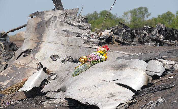 Wreckage of MH17 with flowers placed on the debris, related to Russia found liable by UN aviation agency.