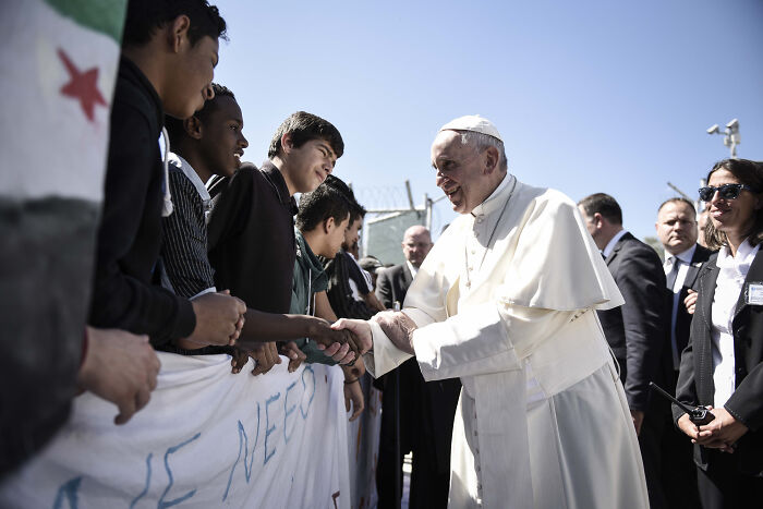 Pope Leo XIV greeting young people outdoors, hinting at his agenda amid MAGA political tensions.