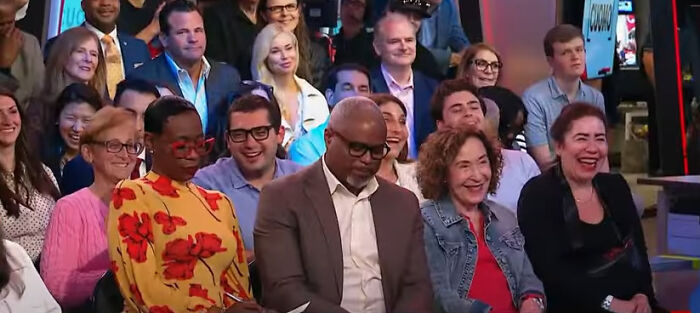 Audience members at a town hall event reacting with laughter during a discussion about Trump&rsquo;s first 100 days.