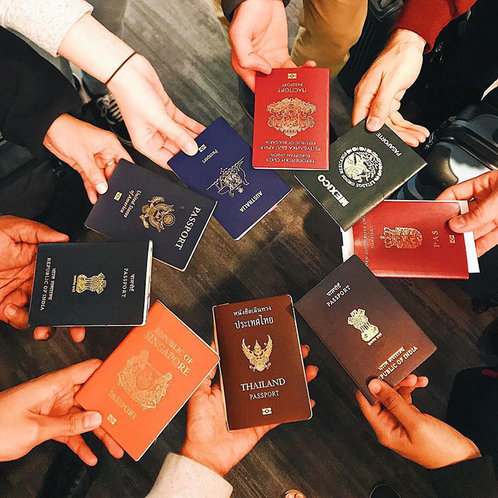 Various international passports held in a circle symbolizing challenges for Harvard international students enrollment under Trump ban
