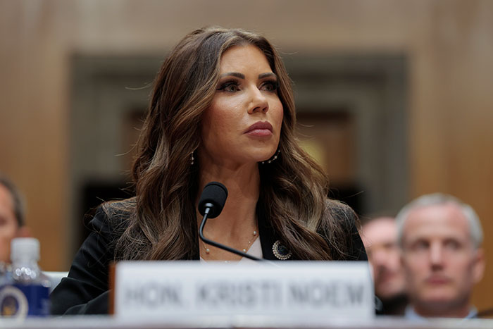 Woman speaking at a formal hearing with microphone, related to Trump bans Harvard international students policy discussion.