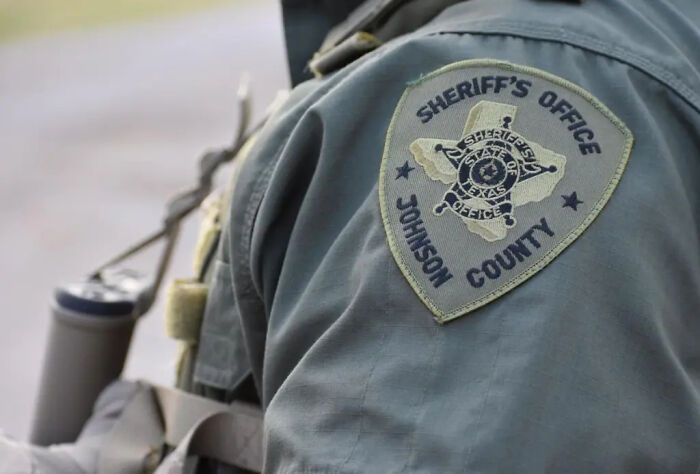 Sheriff's Office patch on officer uniform in Johnson County Texas linked to dystopian surveillance tracking abortion care.