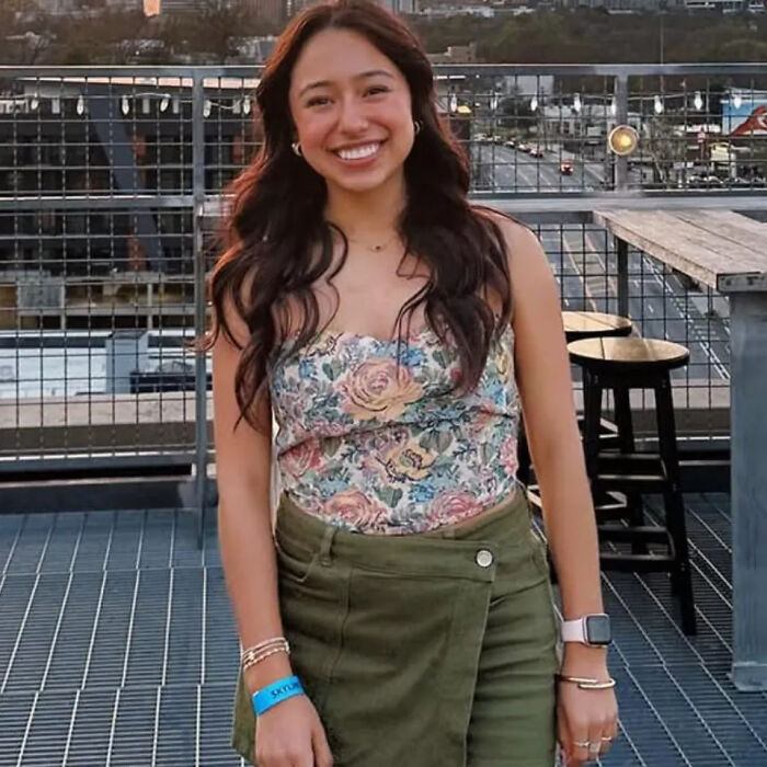 College student smiling outdoors wearing a floral top and green skirt, representing college student facing deportation challenges.