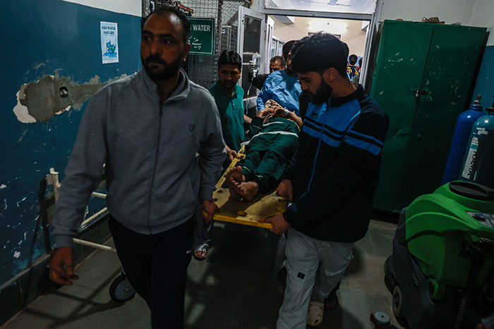 Men carrying an injured person on a stretcher inside a hospital amid India Pakistan conflict raising fears of war.