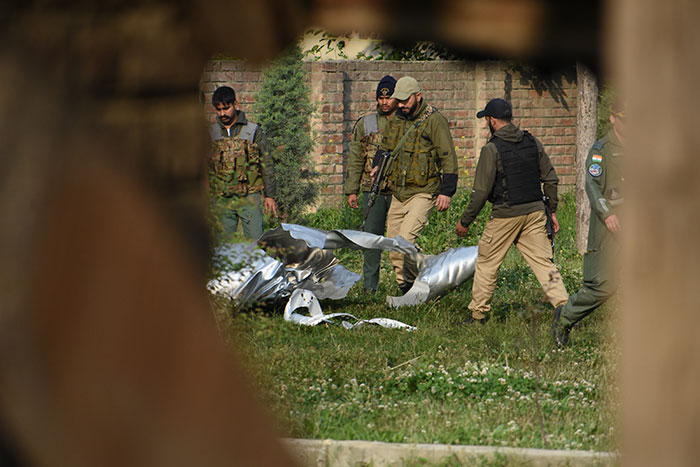 Pakistan security forces inspecting debris of what appears to be a missile or bomb after India bombs Pakistan, raising war fears.