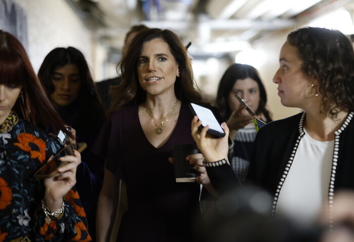 Nancy Mace walking through a crowd during a House hearing addressing a controversial naked image shared without consent.