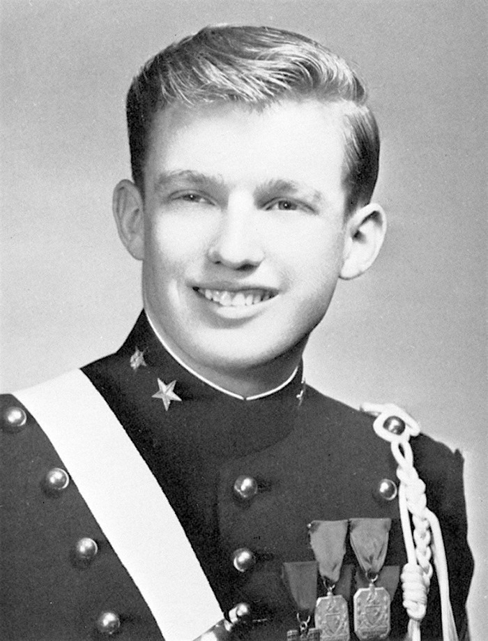 Young Donald Trump in a vintage military uniform smiling, related to biographer uncovering bitterness toward Harvard.