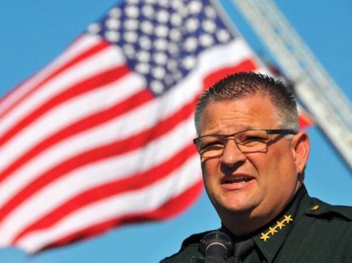 Florida sheriff speaking on camera with American flag in background vowing deadly force against violent ICE protestors